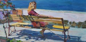 woman sitting on bench by the sea