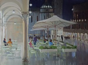 nighttime piazza with umbrellas and café